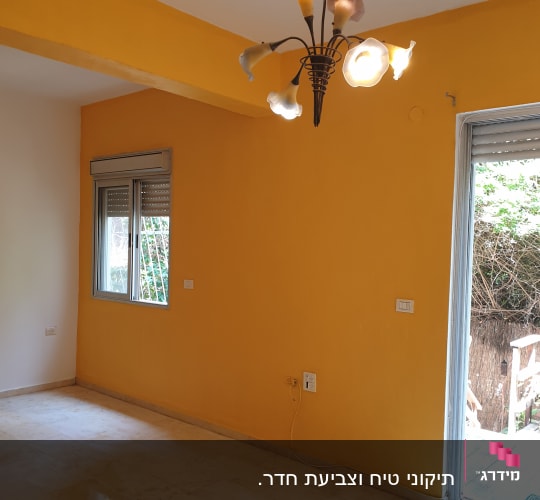 חלל דירה ריק מריהוט שקירותיו נצבעו בצבע צהוב-כתום